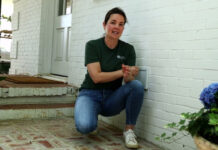 Catherine Arensberg standing next to a white brick home