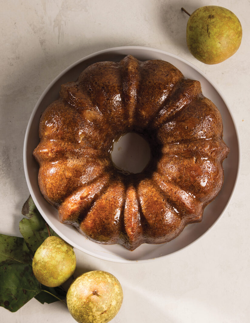 A plated Sand Pear Cardamom bundt cake plated with extra pears on each side.